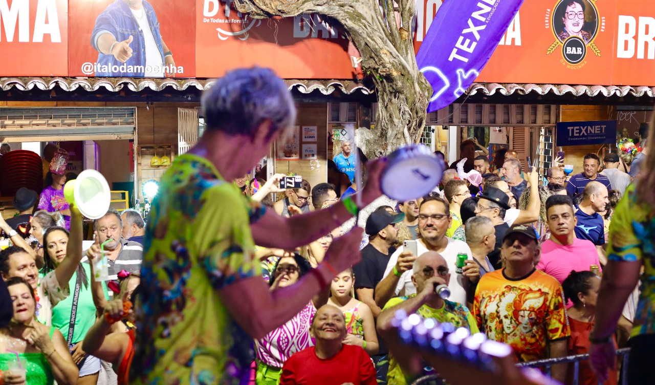 músico do bloco toca tamborim na frente do público